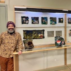 NVRC resident artist Willoughby Arévalo stands next to the completed Felting the Mycelial Web community art project. 