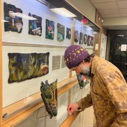 NVRC resident artist Willoughby Arévalo stands next to the completed Felting the Mycelial Web community art project. 