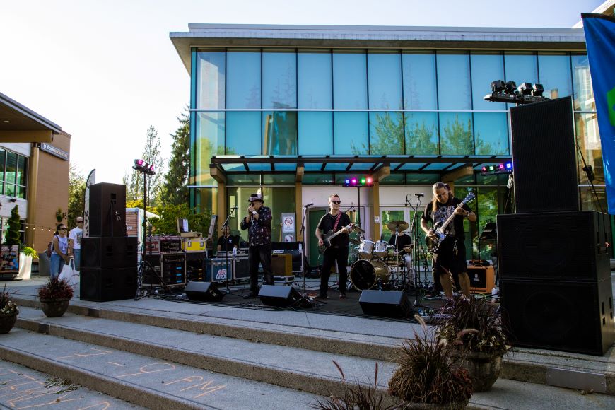 A band performs on a stage in Lynn Valley Village. 