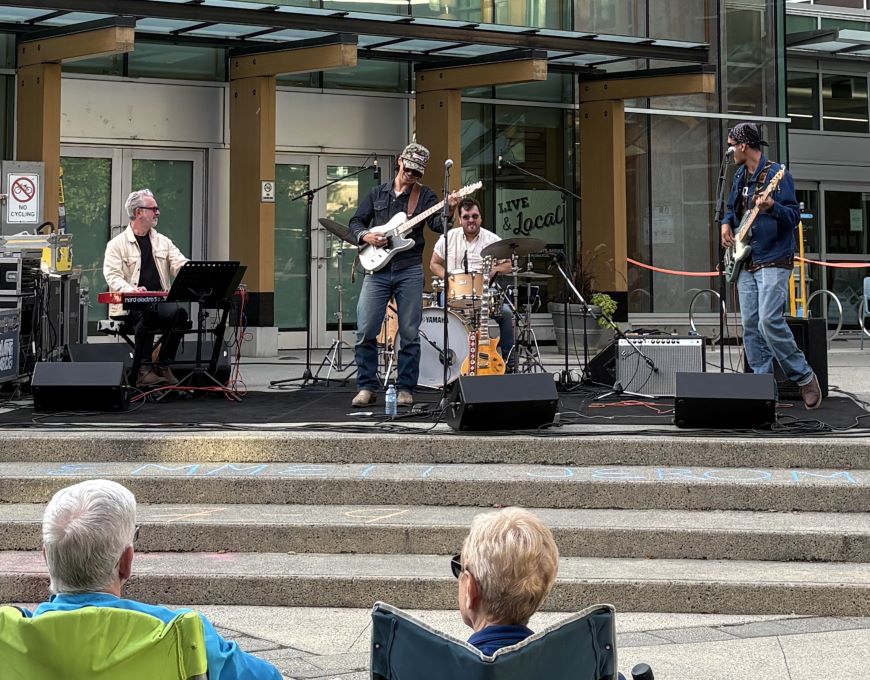 A band performs on a stage in Lynn Valley Village. 