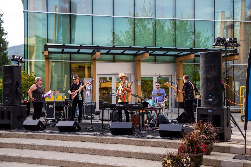 A band performs on a stage in Lynn Valley Village. 