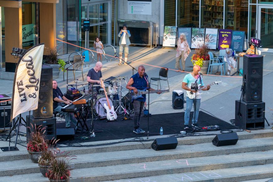 A band performs on a stage in Lynn Valley Village. 