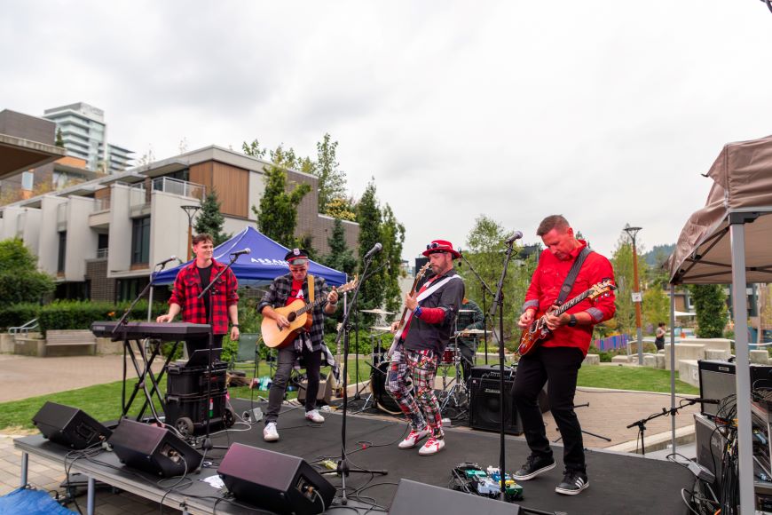 A band performs on a stage in Lions Gate Village