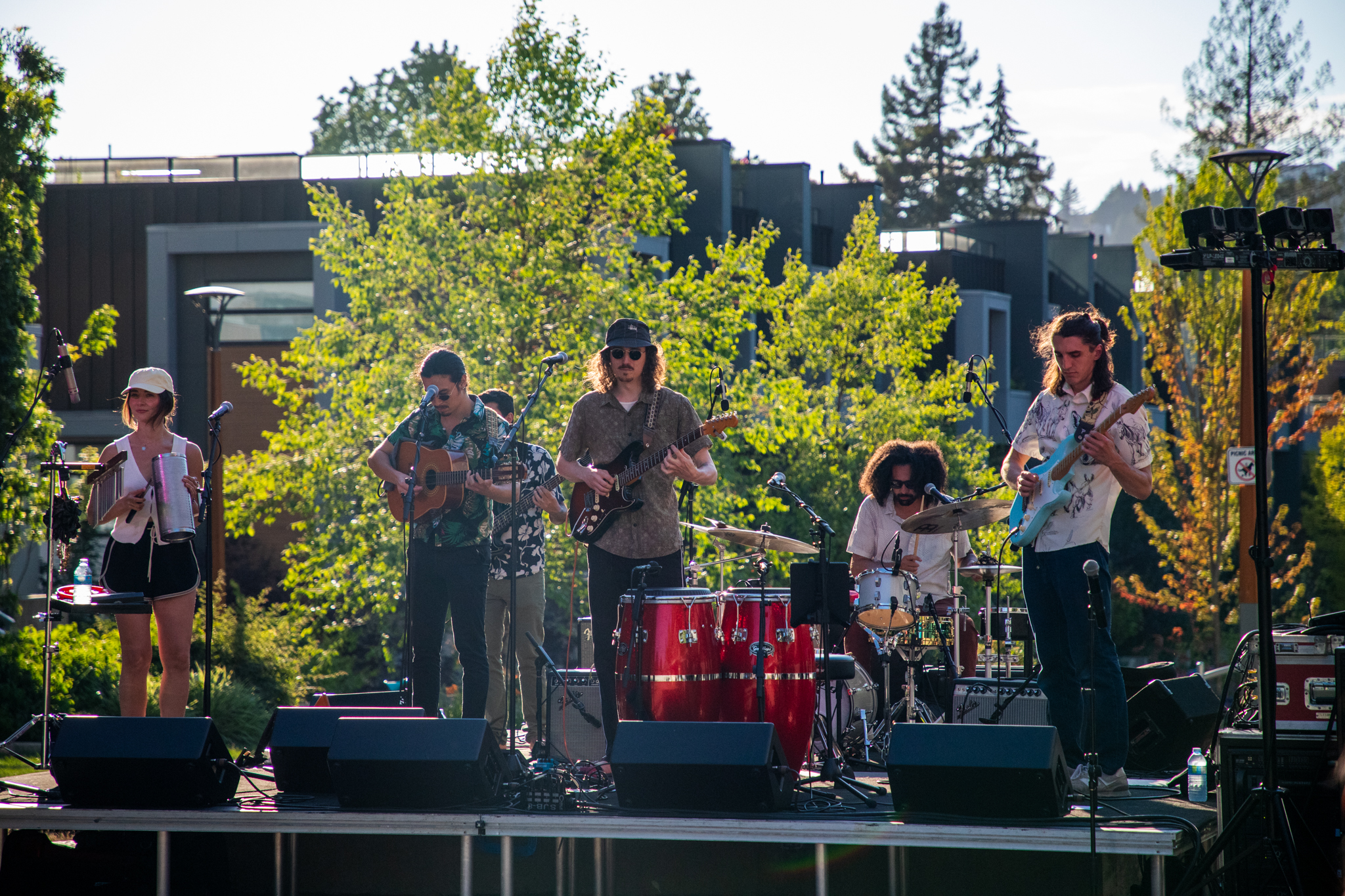 A band plays on a stage in front of a community centre. 