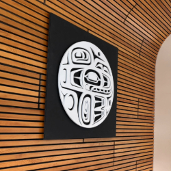 This powder-coated aluminium sculpture depicts a killer whale as a circular white form framed by a black square backing plate.