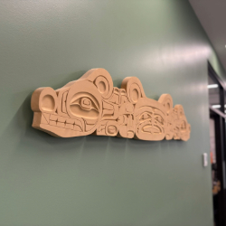 This hand-carved yellow cedar sculpture depicts a three-headed sea serpent, a mythical being.