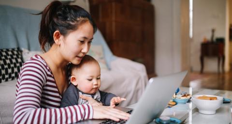Woman and child sitting at laptop computer
