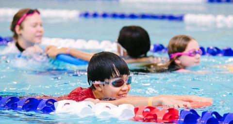 Swim instructor with students in the pool