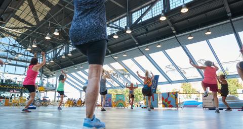 A group participates in an outdoor fitness class at the Shipyards covered plaza in North Vancouver.
