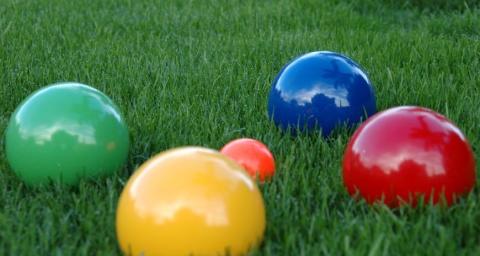 Multi-colour bocce balls on green grass
