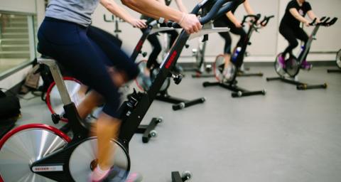 A group of women participate in a spin class