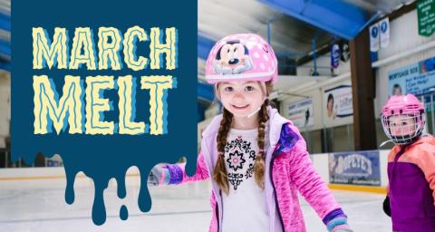 Two young girls wear helmets while skating on an ice rink. 