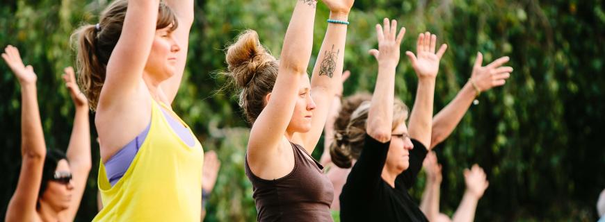 A group of people doing outdoor yoga in the park