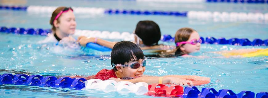 Swim instructor with students in the pool