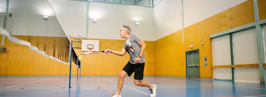 Man plays badminton in Parkgate gymnasium
