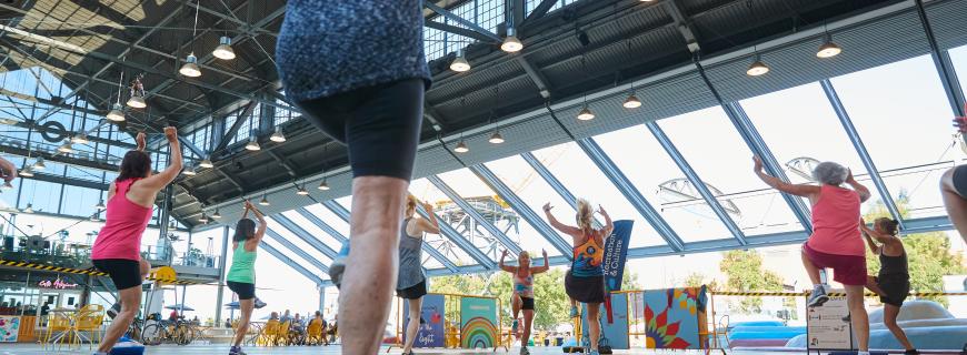 A group participates in an outdoor fitness class at the Shipyards covered plaza in North Vancouver.