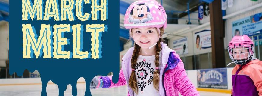 Two young girls wear helmets while skating on an ice rink. 