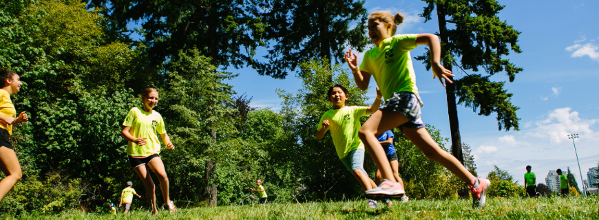 A group of children play tag in a park. 