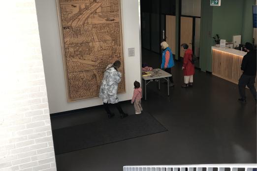 People looking at the wood mural